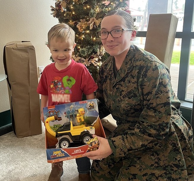 Military mom with little boy receiving a new toy
