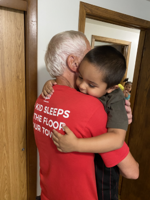 Sleep In Heavenly Peace volunteer hugging a child