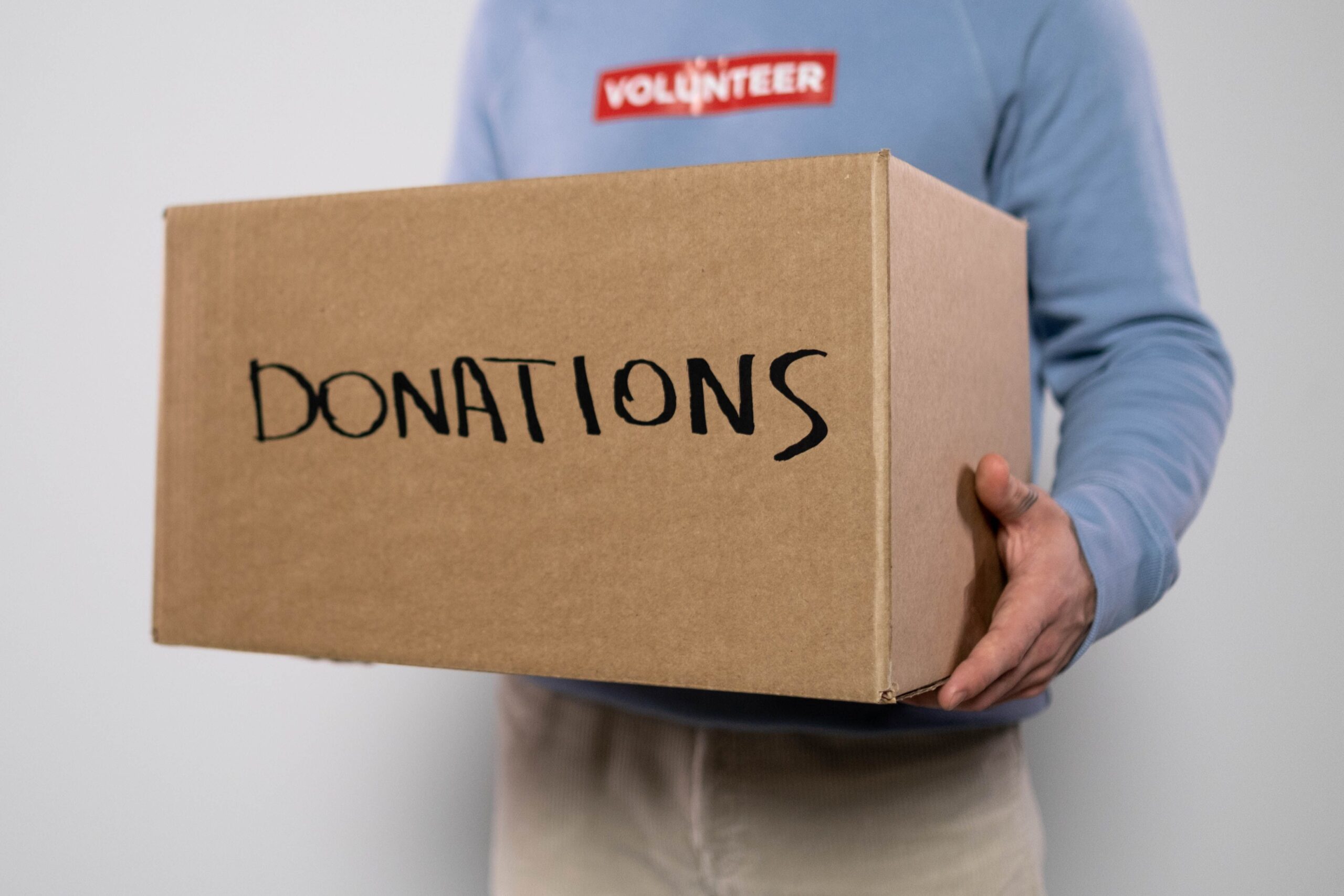 Volunteer holding a box labeled Donations